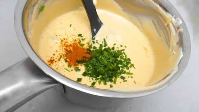 Cheesy chili con queso dip recipe, a popular appetizer dip with melted cheese, a dash of chili powder and some fresh bell pepper...
