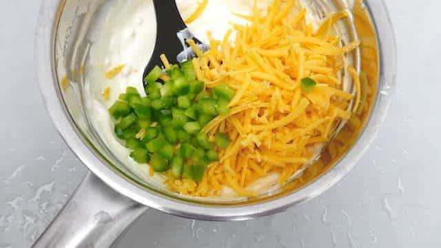 Cheesy chili con queso dip recipe, a popular appetizer dip with melted cheese, a dash of chili powder and some fresh bell pepper...
