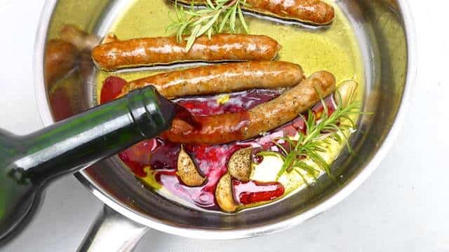 Delicious roasted sausage with soft garlic cloves and red wine... Served over buttery mashed potatoes or creamy polenta: flavor bomb!