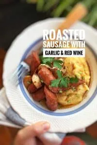 Delicious roasted sausage with soft garlic cloves and red wine... Served over buttery mashed potatoes or creamy polenta: flavor bomb!