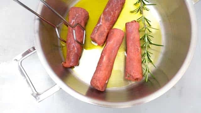 Braciole di manzo, juicy Italian stuffed beef rolls with olives, eggs, ham and basil! Braised in a chunky tomato sauce...