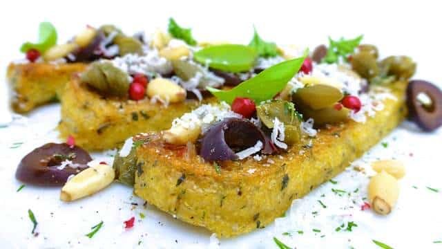 Try this very easy grilled polenta: with pine nuts, black olives and grated parmesan cheese... Serve it as a light lunch or a veggie side dish!