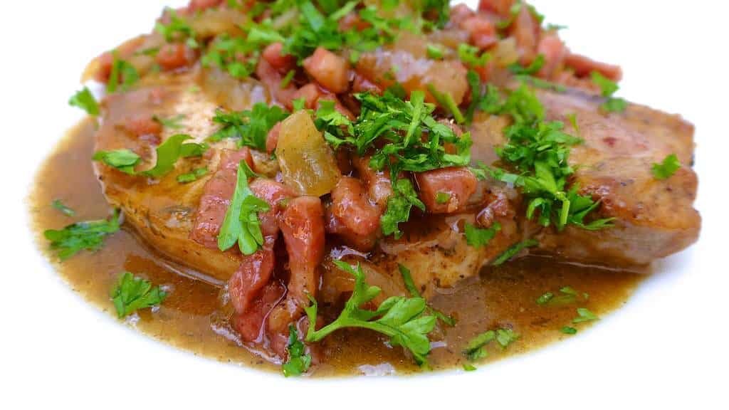 Succulent baked pork chops in beer sauce with crunchy bacon bits and soft onion... No need to say how fantastic this recipe tastes!