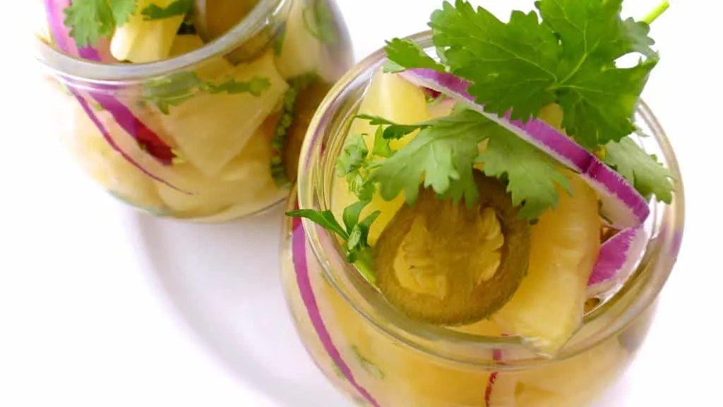 Got leftover pineapple? Make this spicy pickled pineapple with jalapeño and cilantro! Lovely in combination with cold cuts, cheese or roast dinners.
