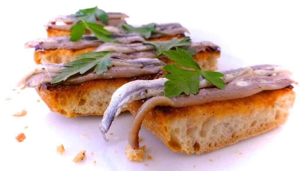 Crunchy Spanish tosta matrimonio or pickled anchovies and salted anchovies on a slice of pan con tomate, the perfect wedding!
