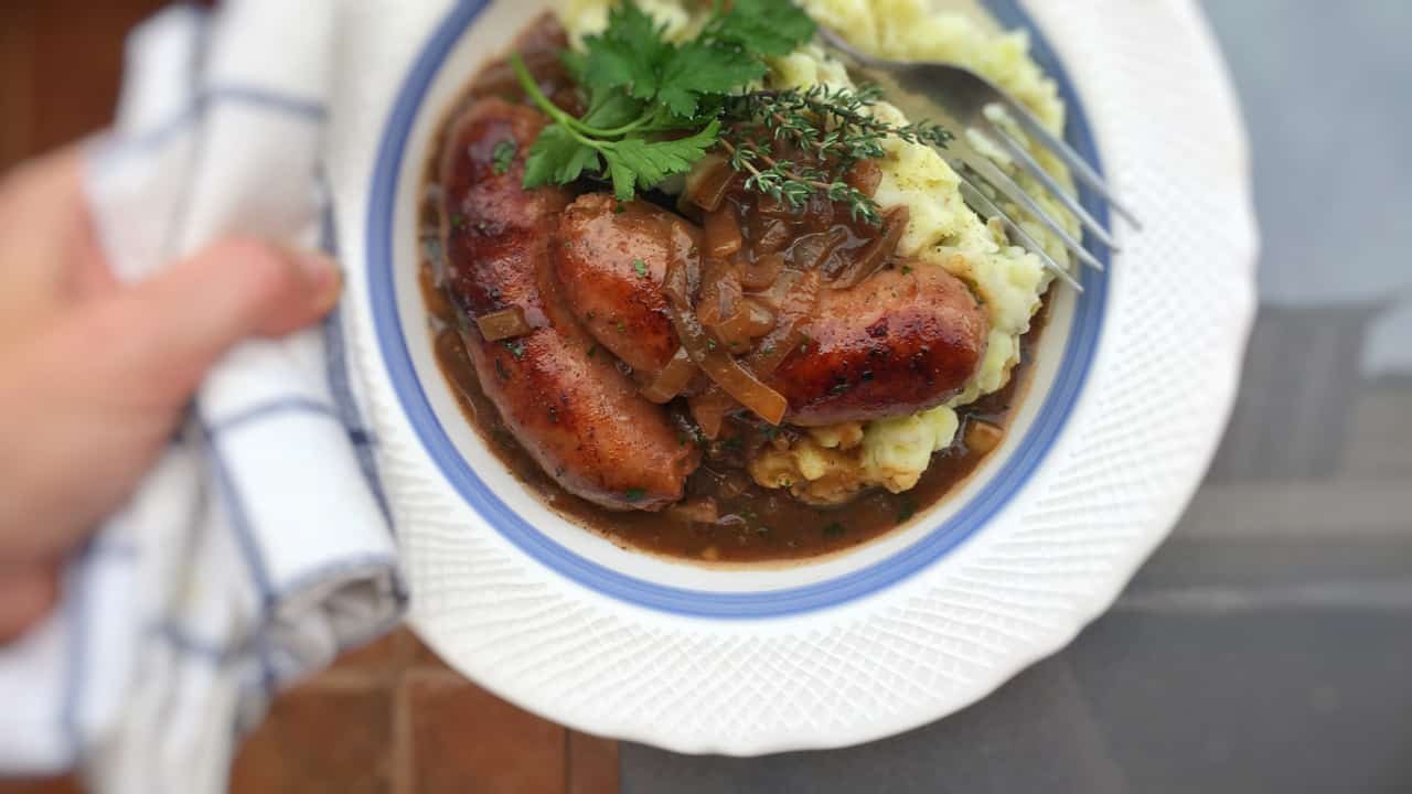 This is hands down my husband's favorite comfort food: fried bangers and creamy potato mash topped off with a strong Guinness and onion gravy!