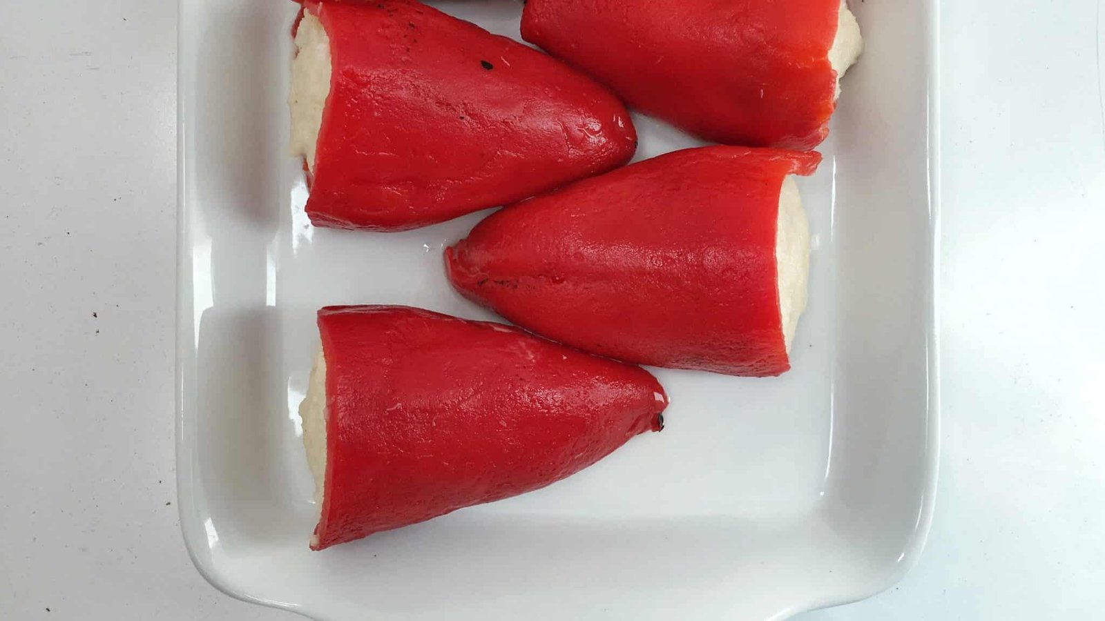 Warm piquillo peppers stuffed with salt cod in cream sauce: easy to make in advance and a perfect starter for large dinner parties!