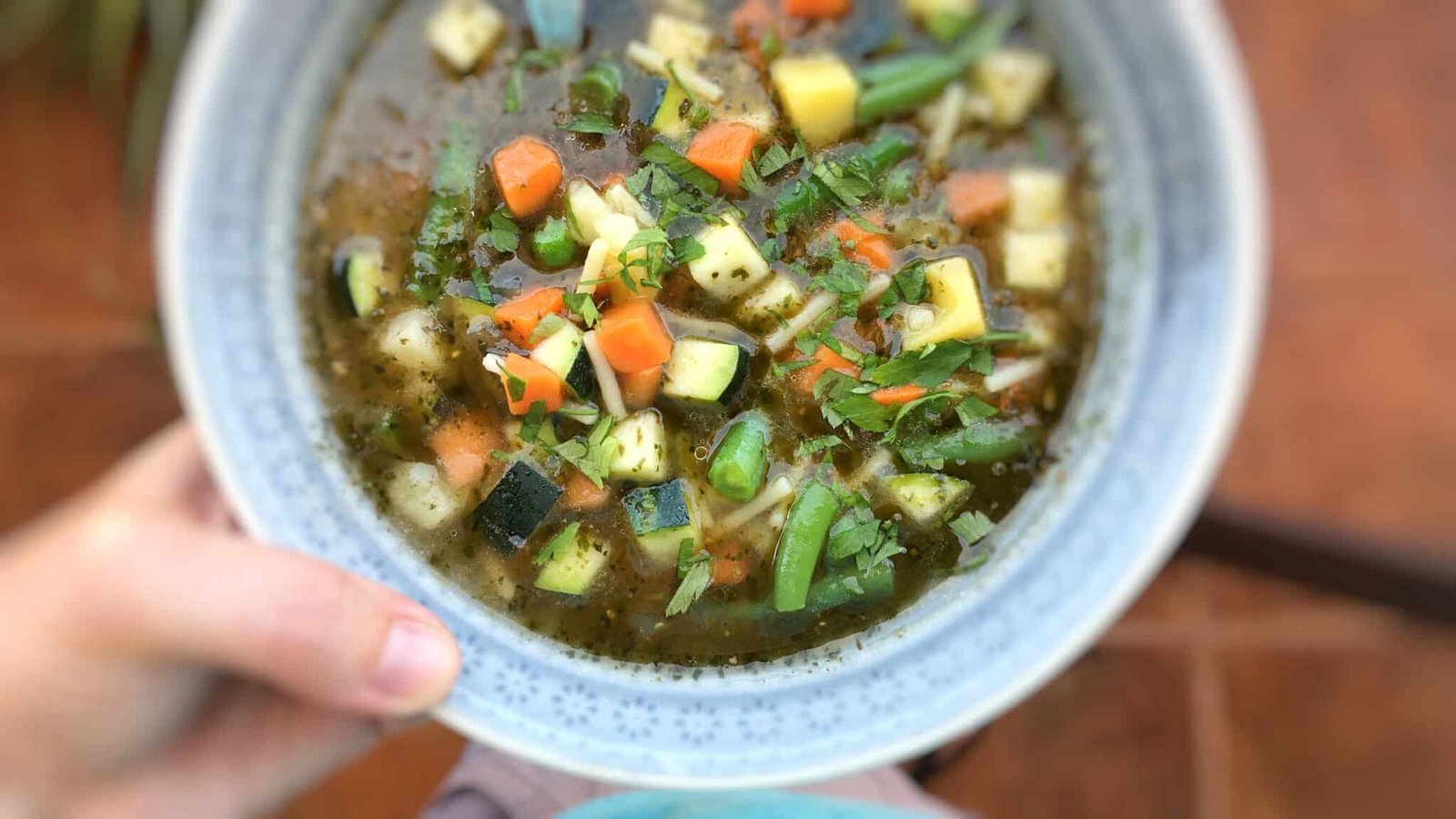 French pistou soup: a provençal chunky vegetable soup with peas, green beans, potatoes, zucchini and a spoonful of basil pesto...