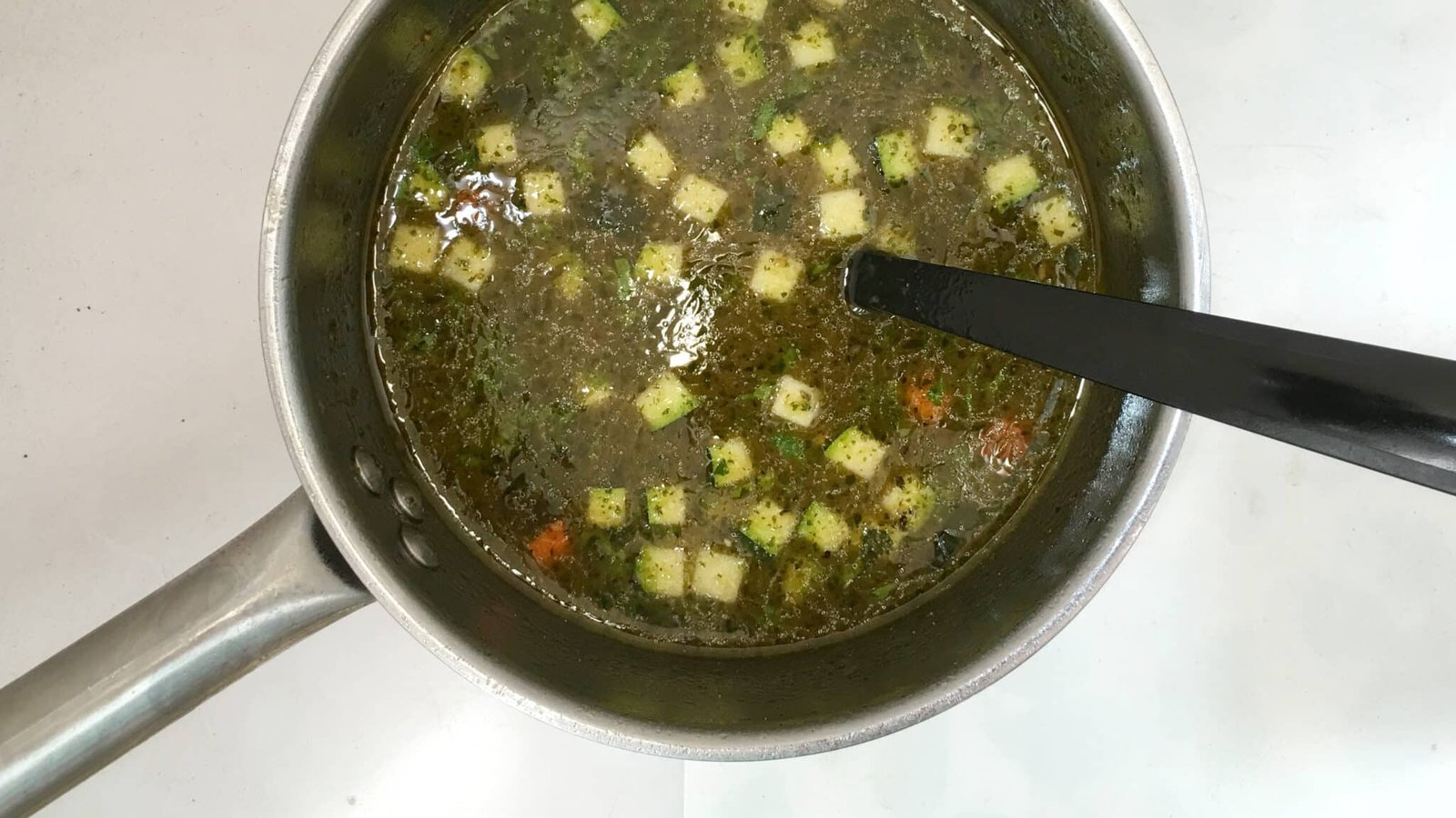 French pistou soup: a provençal chunky vegetable soup with peas, green beans, potatoes, zucchini and a spoonful of basil pesto...