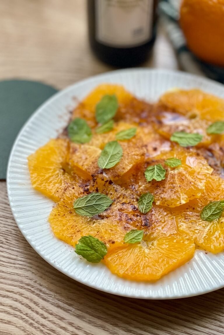 Best Mediterranean Orange Carpaccio (Fresh Citrus Carpaccio Dessert) Mediterranean orange carpaccio with olive oil, cinnamon, and mint on a white plate.